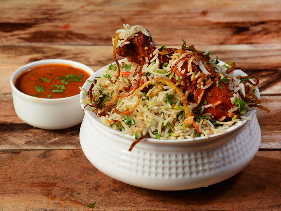 Traditional Hyderabadi Chicken dum Biryani made of Basmati rice cooked with masala spices, served with Salan, selective focus